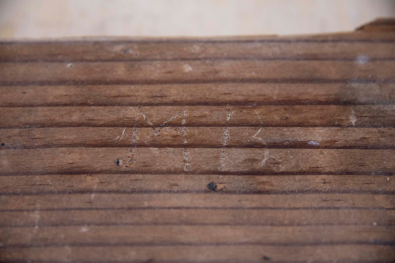Image of wooden board with the initials 'MB' carved into it
