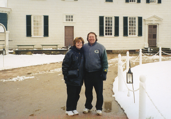 Scott and Lynn Molitor pose in front of the Mansion during the winter
