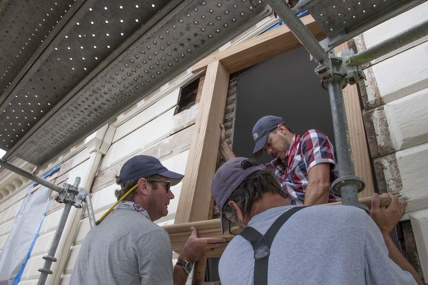 Carpenters installing new window frames.